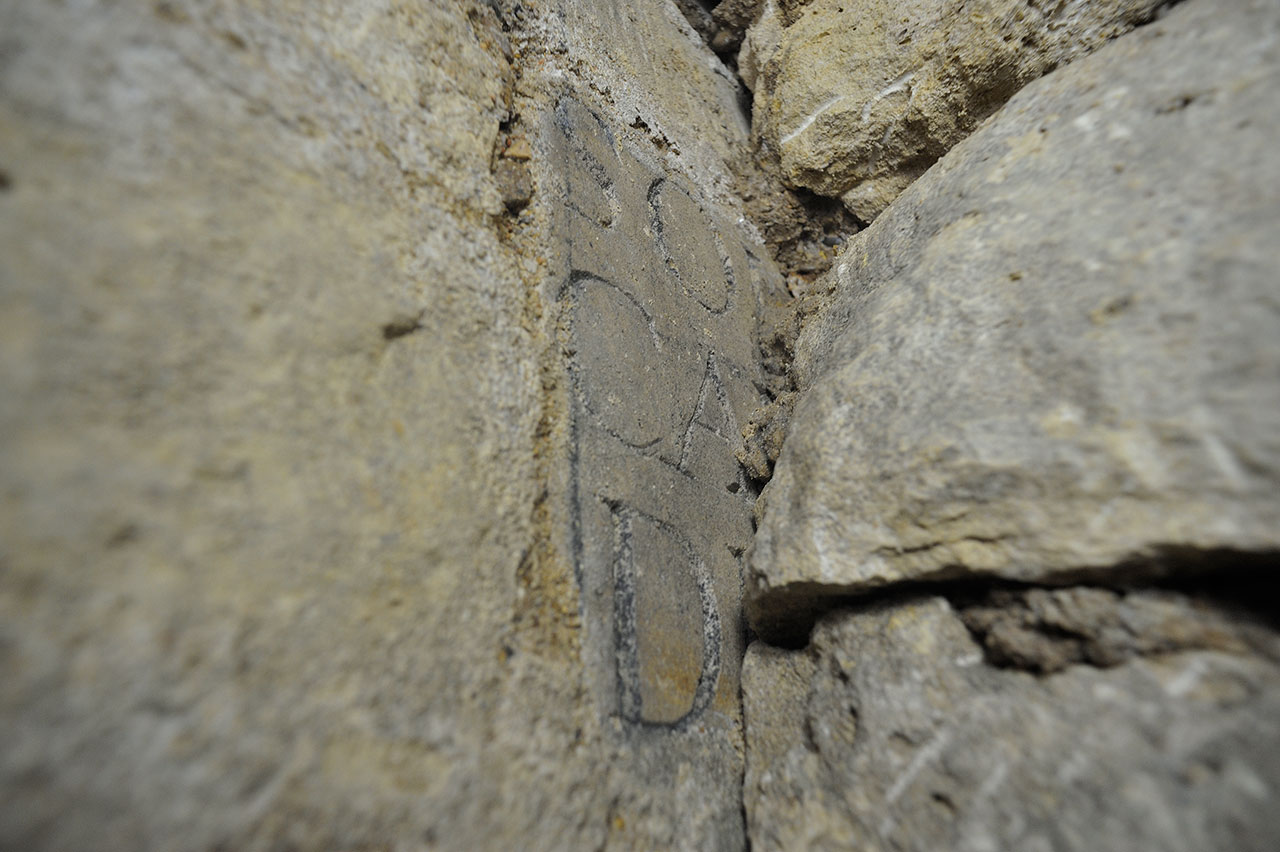 Les restes d'un plaque incrustée dans une maçonnerie.